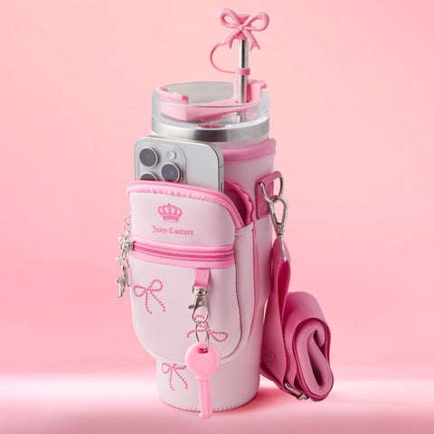 The Jetsetter Hydration Stainless Steel Tumbler with a pink neoprene crossbody pouch features bow accents, a crown logo, zipper, detachable strap, and fits a phone and pink straw—all styled on a matching pink background.