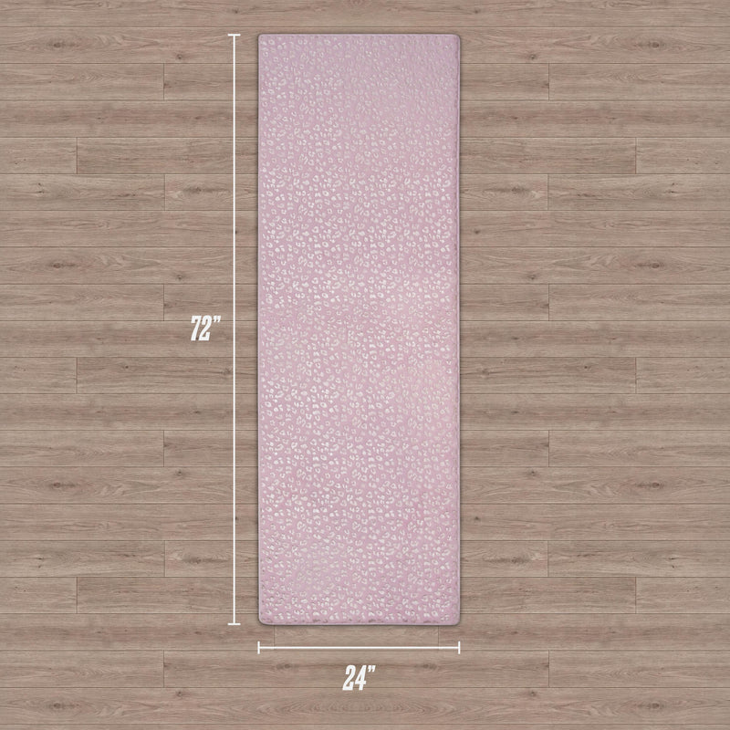 A Metallic Leopard Plush Rug, 2' x 6', in hot pink with a textured pattern is laid on a wooden floor.