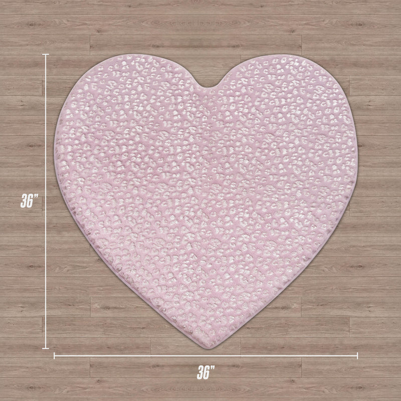 A Juicy Couture Metallic Leopard Plush Rug, 3' Heart, in light pink with a subtle textured pattern, lies on wood flooring. White measurement lines and labels show the rug measures 36" x 36".