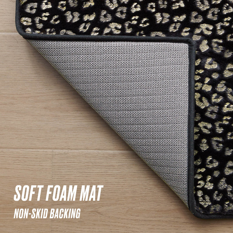 A partially flipped black Metallic Leopard Plush Rug, 2' x 6', shows off its gold and beige leopard print and textured gray non-skid backing. The image reads: Soft foam mat, non-skid backing.
