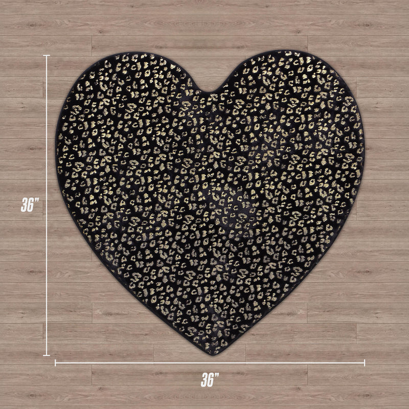 The Metallic Leopard Plush Rug, 3' Heart, is a heart-shaped black rug with a gold metallic leopard print pattern, shown on a wood floor and labeled as 36 inches by 36 inches.