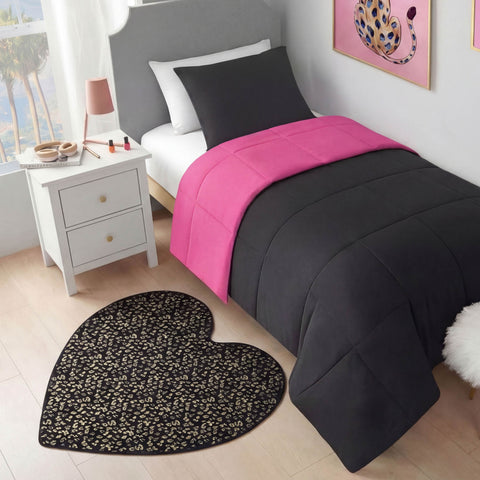 A neatly made bed with a black comforter and bright pink blanket sits by a white nightstand. On the floor is a Metallic Leopard Plush Rug, 3' Heart, and colorful leopard wall art hangs above the bed.