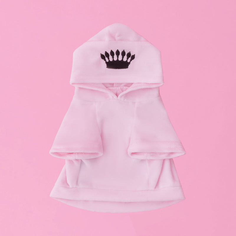 A light pink Bling Velour Pet Hoodie featuring short sleeves, a hood adorned with a black crown emblem, and displayed against a solid pink background—ideal for those looking for playful luxury in designer pet apparel.