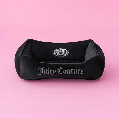 The Crown Bling Black Pet Bed, featuring a silver embroidered logo and crown design, is displayed on a solid pink background.