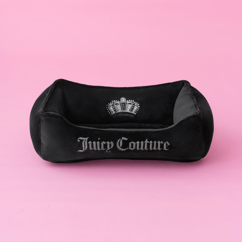 The Crown Bling Black Pet Bed, featuring a silver embroidered logo and crown design, is displayed on a solid pink background.