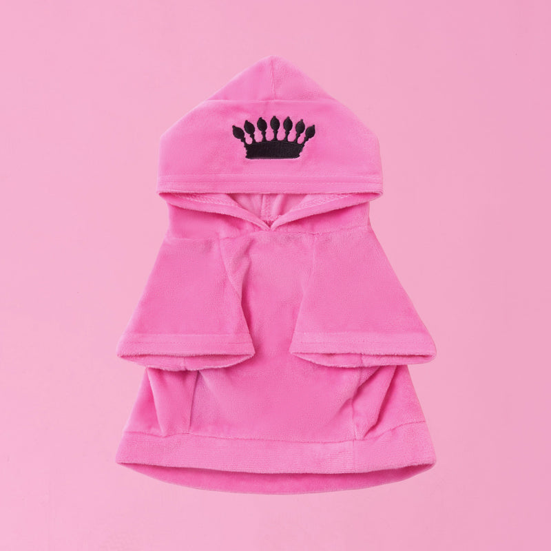 The Bling Velour Pet Hoodie, featuring a pink hue, wide sleeves, a hood adorned with a black crown emblem, and Juicy Couture-inspired style, is showcased against a solid pink background.