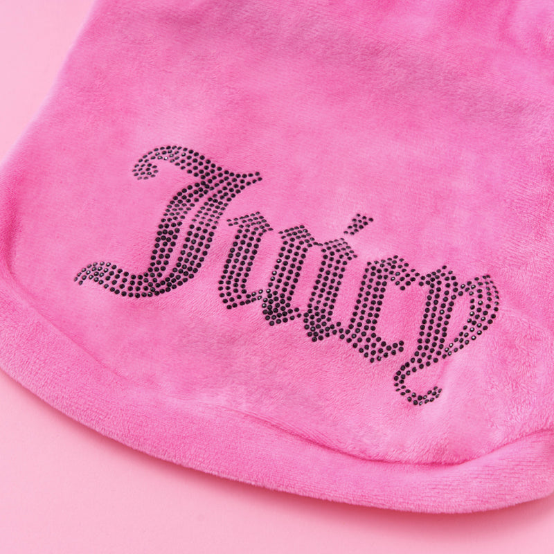 A close-up of the Bling Velour Pet Hoodie in pink velour fabric features the word “Juicy” spelled out in decorative black rhinestones, showcasing the signature bling style of this Juicy Couture pet hoodie.