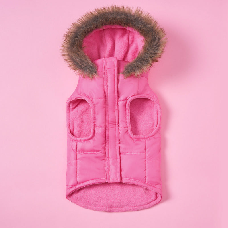 The Pet Faux Fur Hooded Jacket is a pink quilted vest for pets, featuring a hood lined with brown faux fur. Displayed on a pink background, this jacket comes with two armholes and a convenient front zipper. It’s the ideal choice for fashionable pets to stay warm and stylish during chilly days, ensuring your furry friend remains cozy and trendy all season long.