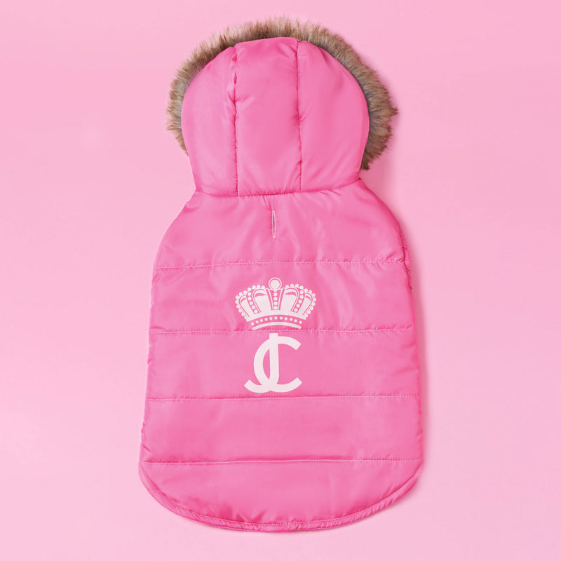 Introducing the Pet Faux Fur Hooded Jacket: a pink, padded hooded pet jacket with a faux fur-trimmed hood, adorned with a white crown and interlocking JC logo on the back. This classic Juicy Couture cold-weather essential for dogs is displayed on a pink background.