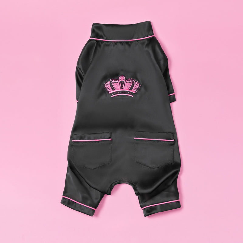 Dressed in luxurious black satin with pink trim and a crown emblem on the back, the Juicy Couture Pet Silky Satin Pajamas—shown on a pink background—give your furry friend a stylish, high-end look.