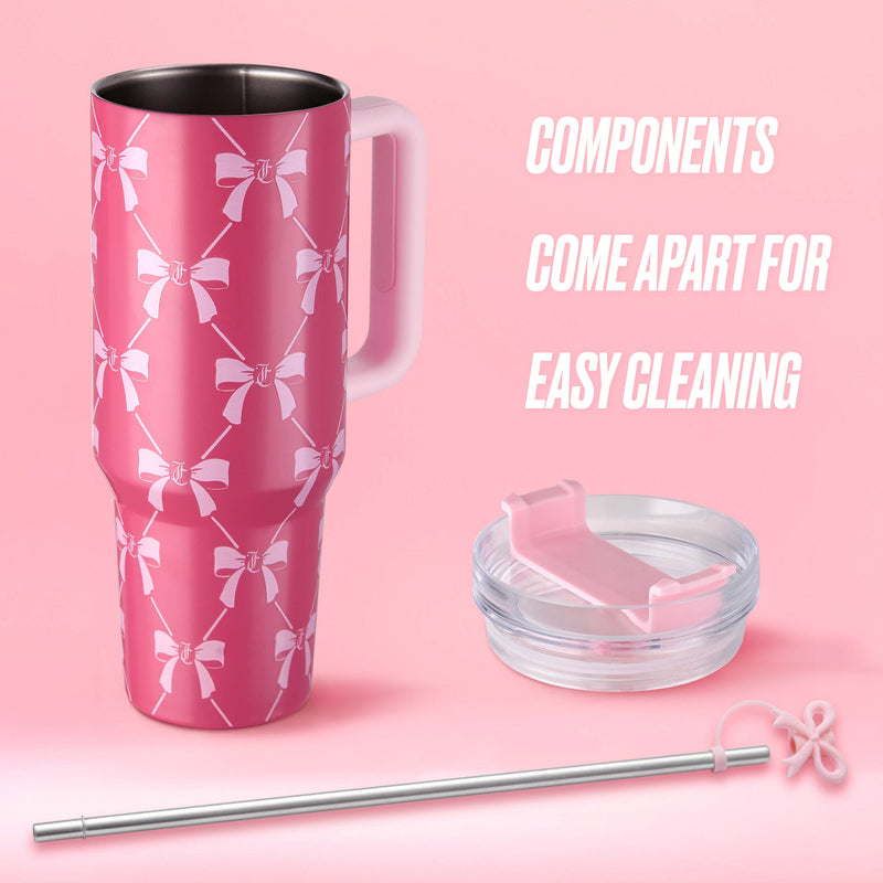 The Jetsetter Hydration Stainless Steel Tumbler, 40 oz, in pink features white bows, a clear lid, and a reusable metal straw with a loop. All parts detach for easy cleaning—a chic travel cup for hydration on the go.