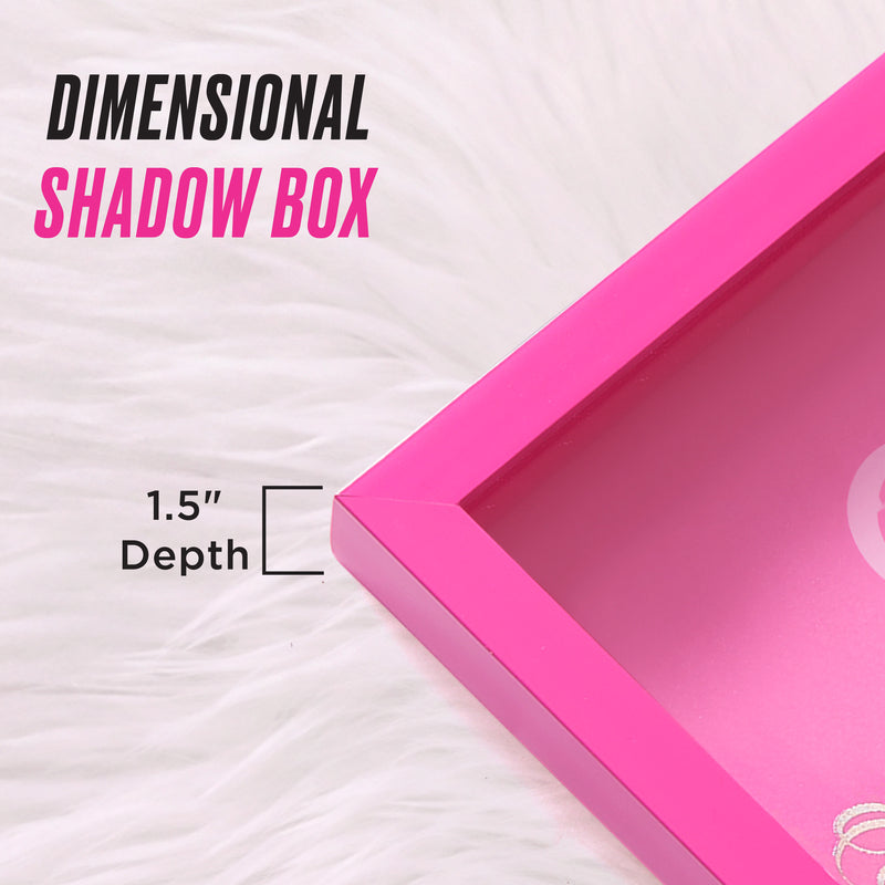A close-up of a pink Shadow Box Wall Art, 12″ x 16″, with a 1.5″ depth, displayed on a white fur surface. This stylish dimensional shadow box features text that reads: DIMENSIONAL SHADOW BOX and 1.5 Depth, along with a depth line diagram—perfect for adding a chic, fashion-inspired accent to any space.