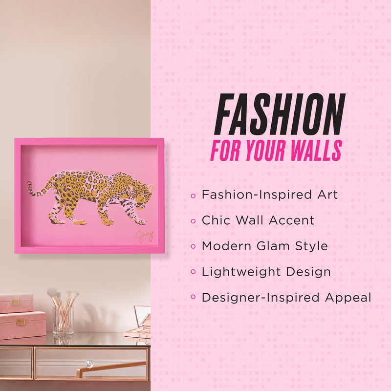 A fashion-inspired Shadow Box Wall Art (12″ x 16″) with a chic pink frame and leopard print design hangs above a desk with books and a glass, serving as a modern glam accent piece. Its lightweight construction and designer appeal make it the perfect stylish wall décor for any contemporary space.