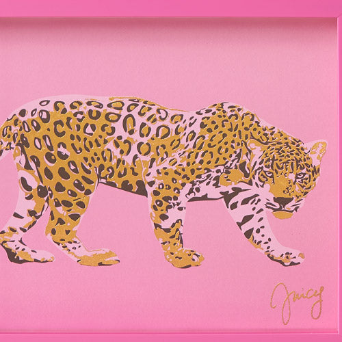 A stylized illustration of a leopard with yellow and black spots walks across a pink background, with the word “Juicy” signed in gold in the lower right corner. This fashion-inspired Shadow Box Wall Art (12″ x 16″) evokes the playful elegance of Juicy Couture, making it a striking addition to any stylish space.