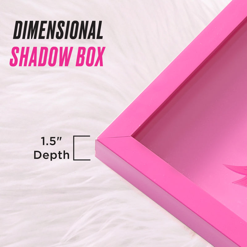 A close-up of the Shadow Box Wall Art, 14″ x 14″, featuring a stylish pink design with a 1.5-inch depth, displayed on a white, fluffy surface. This fashion-inspired piece brings a chic accent to any room. Text reads: Dimensional Shadow Box and 1.5 Depth.