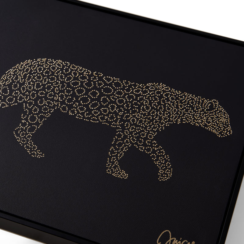 A gold dotted outline of a walking leopard appears on a black rectangular surface, accented by a signature in the bottom right corner. This elegant design creates a fashion-inspired aesthetic reminiscent of Juicy Couture, as featured in the Shadow Box Wall Art, 16″ x 20″.