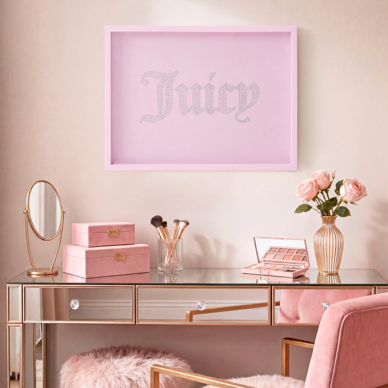 A glamorous vanity table with pink accents, makeup brushes, pink boxes, a small mirror, and a vase of roses sits beneath a framed Shadow Box Wall Art (18″ x 24″), adding a sophisticated artistic touch to the chic space.