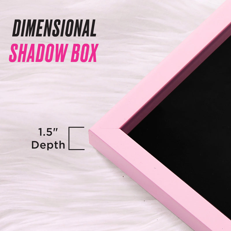 Close-up of a pink picture frame with a black center on a white fur surface, highlighting the luxe appeal of the Shadow Box Wall Art, 18″ x 24″. Text reads DIMENSIONAL SHADOW BOX, and a label indicates 1.5″ depth with a bracket marking the thickness—perfect for showcasing your favorite fashion-inspired artwork in bold shadow box art style.