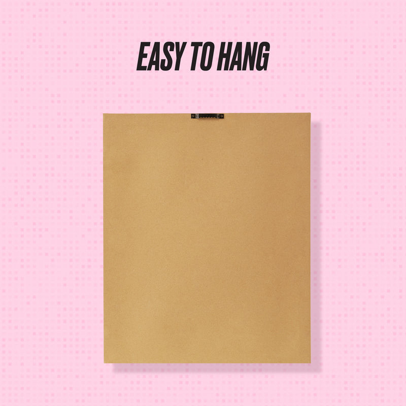 The Shadow Box Wall Art, 18″ x 24″, is displayed from the back against a pink background, featuring a square brown frame with a metal hanging bracket. The design makes it easy to hang your favorite fashion-inspired artwork or shadow box creations. Text at the top reads EASY TO HANG.