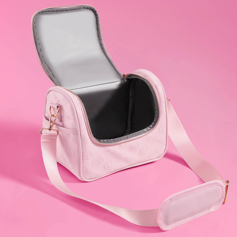 A light pink, rectangular Lunch Purse Cooler Bag by Juicy Couture, featuring an open top flap, gray interior, and adjustable strap, sits on a pink background.