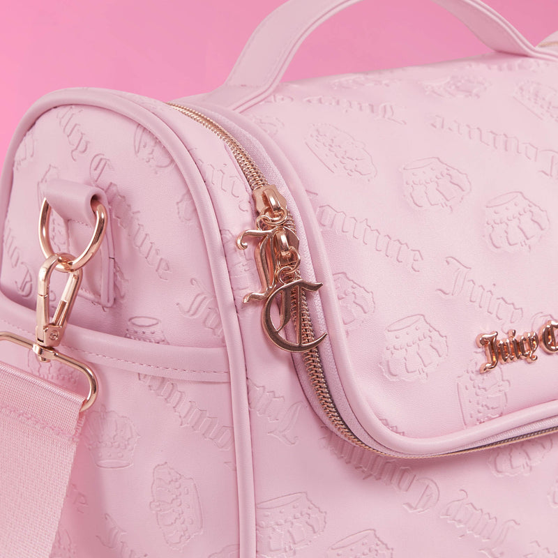Close-up of a light pink Lunch Purse Cooler Bag by Juicy Couture, accented with gold zippers and hardware. The bag features the embossed Juicy Couture logo on its material and includes a coordinating pink strap, set against a pink background. This insulated lunch tote combines style and function, making it perfect for keeping your meals fresh wherever you go.