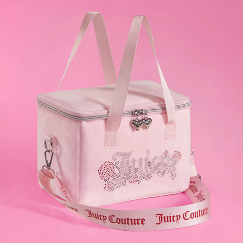 A pink Chill Couture Cooler Bag featuring a sparkling rhinestone Juicy Couture logo, pink handles, and a detachable strap adorned with “Juicy Couture” lettering. Set against a matching pink background, this stylish lunch tote doubles as an insulated cooler bag—perfect for keeping your meals fresh and chic wherever you go.
