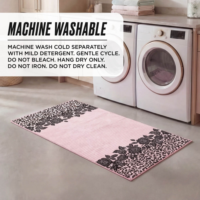 A laundry room with washer and dryer features a Finely Washable Rug, 2' x 4', in pink and black florals. This ultra-soft rug is machine-washable: cold wash, gentle cycle, no bleach, hang dry; do not iron or dry clean.