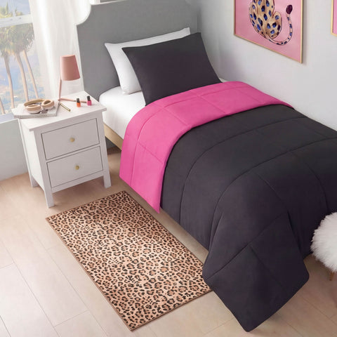 A neatly made bed with dark gray and bright pink bedding sits beside a white nightstand. On the floor is the Finely Washable Rug, 2' x 4', featuring a cheetah print—ultra-soft and machine-washable—a cheetah artwork hangs on the wall.