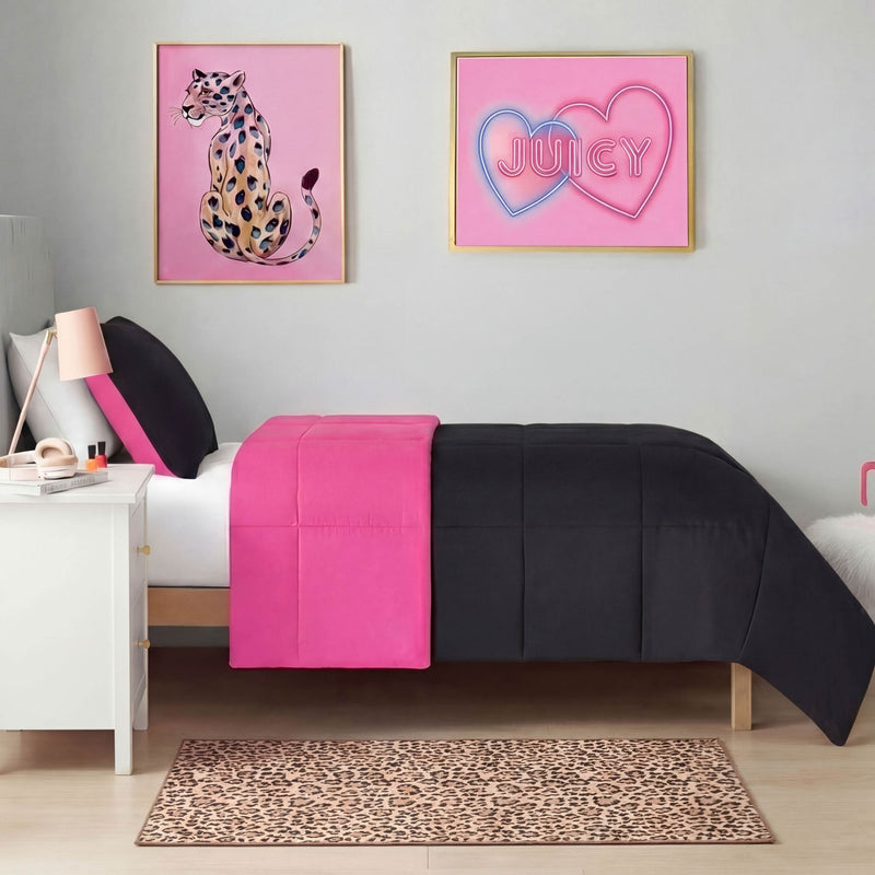 A modern bedroom features a bed with black and bright pink bedding, a white nightstand with lamp, wall art of a leopard and neon JUICY hearts, plus the Finely Washable Rug, 2' x 4', from Juicy Couture for extra flair on the floor.