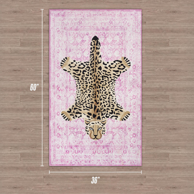 A rectangular Juicy Couture Finely Washable Rug in pink with a central leopard print is shown on a wood floor. This ultra-soft 3' x 5' rug adds a chic touch to any space.
