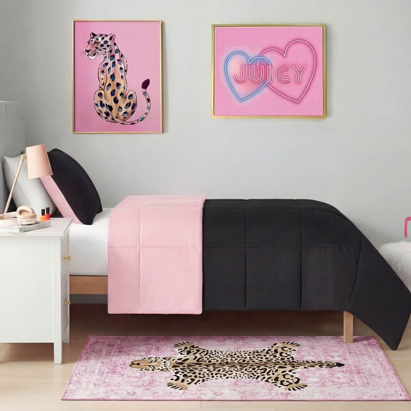 A modern bedroom with a single bed dressed in black and pink bedding, leopard-themed wall art, and a Finely Washable Rug (3' x 5') in pink leopard print. A white nightstand with a lamp is placed beside the bed.