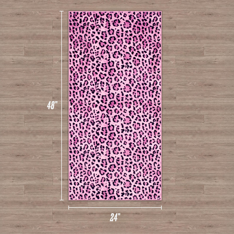 A Finely Washable Rug, 2' x 4', with a pink and black leopard print pattern is displayed on a wooden floor. The ultra-soft rug measures 48 inches long by 24 inches wide.