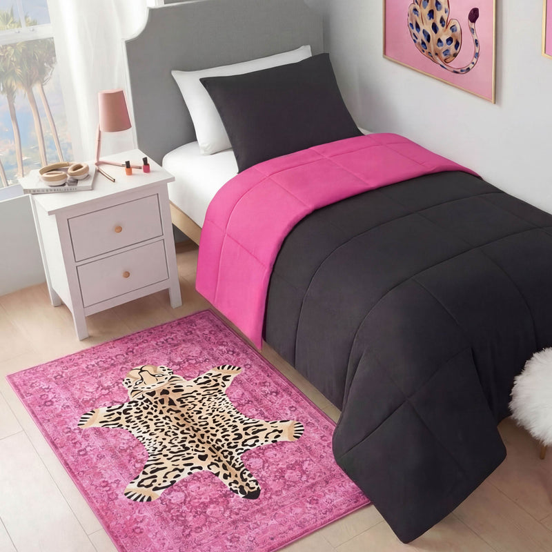 A modern bedroom with a bed in black and hot pink bedding, a white nightstand with makeup, a pink lamp, leopard art on the wall, and an ultra-soft Finely Washable Rug (3' x 5') with a leopard print design on the floor.