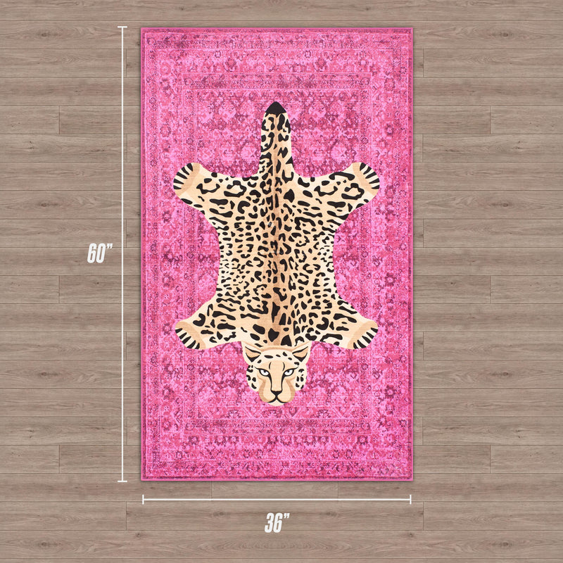 The Finely Washable Rug, 3' x 5', is a rectangular pink ultra-soft rug with a central leopard print design, styled like leopard skin and shown on a wooden floor.