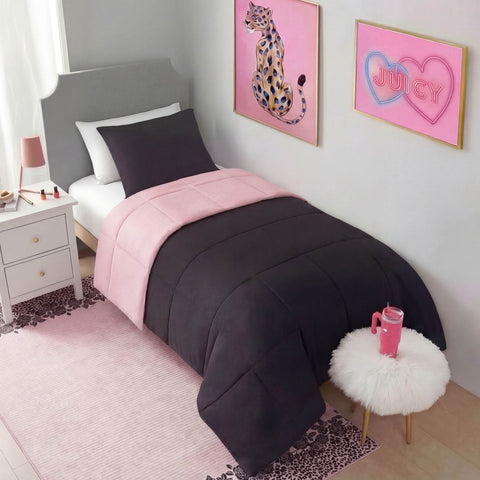 A neatly made bed with a two-tone pink and black comforter, dark pillow, and pink wall art sits beside a white nightstand. The room features a Finely Washable Rug, 5' x 7', plus a furry round stool with a pink tumbler.