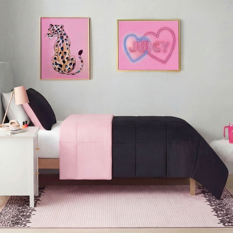 A neatly made twin bed with black and pink bedding sits against a light gray wall. Above the bed are framed cheetah and neon JUICY hearts art. A Finely Washable Rug, 5' x 7', and pink accents complete the room.