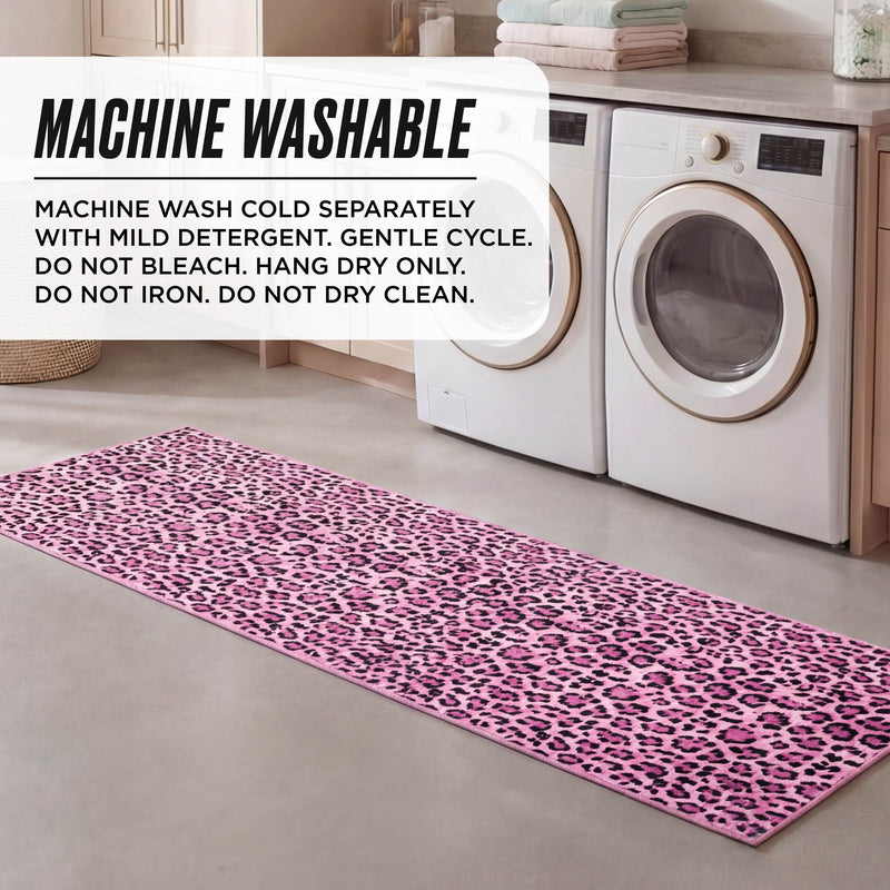 A pink Finely Washable Rug, 2' x 6', with a leopard print is placed in front of a washer and dryer in the laundry room. Above the ultra-soft, machine-washable rug are care instructions for easy cleaning.