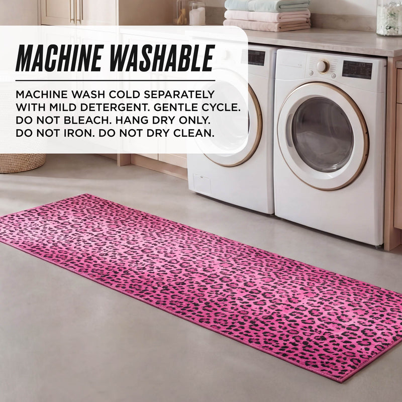 A Finely Washable Rug, 2' x 6', in pink leopard print lies in front of a washer and dryer. Care: Machine wash cold separately with mild detergent, gentle cycle. Do not bleach, iron, or dry clean. Hang dry only.
