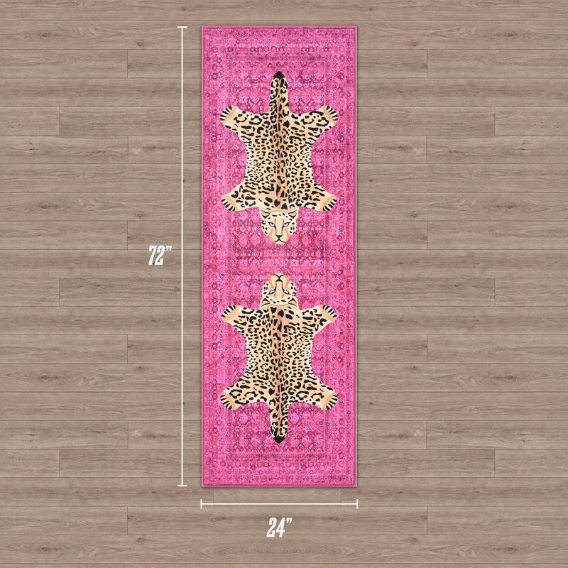 A pink rectangular Finely Washable Rug, 2' x 6', featuring two leopard designs in the center and shown on a wood floor. The ultra-soft rug's dimensions are clearly labeled along the sides.