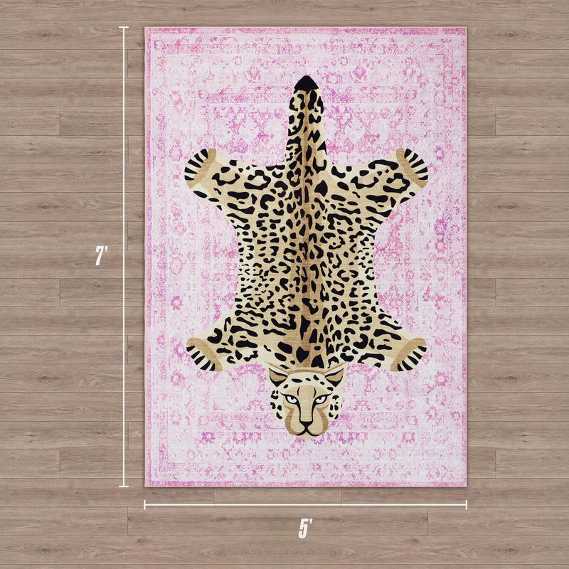 A rectangular pink Finely Washable Rug, 5' x 7', features a leopard-print center shaped like a stretched-out leopard and lies on a wooden floor.