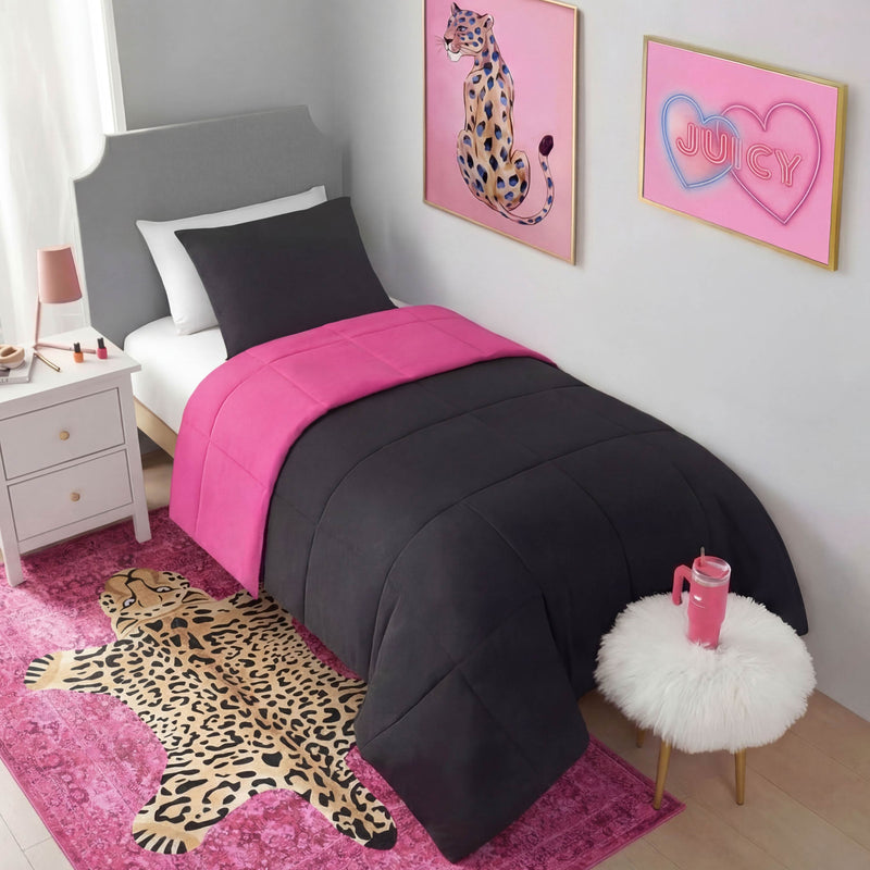 A twin bed with black and hot pink bedding sits beside a white nightstand and fluffy stool. Leopard art and a pink "JUICY" sign hang above, while the Finely Washable Rug, 5' x 7', and chic pink accents complete the room.