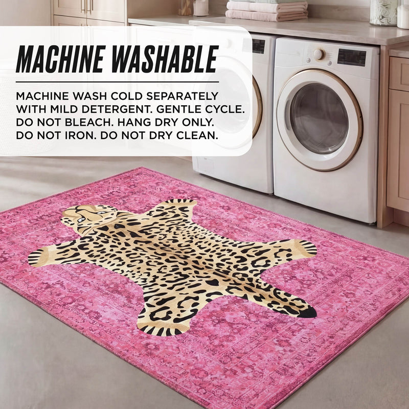 A laundry room with a washer, dryer, and the Finely Washable Rug (5' x 7') in pink cheetah print. Text overlay: machine wash cold, gentle cycle, hang dry; do not bleach, iron, or dry clean.