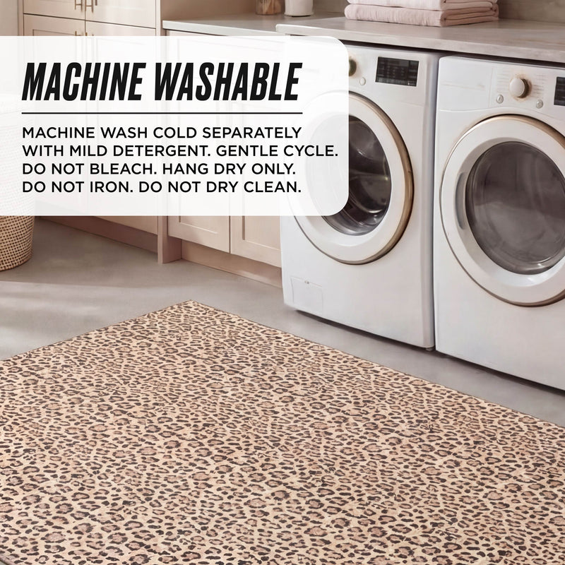 A laundry room with two front-load washers, a beige cabinet, and the Finely Washable Rug (7'10 x 10') in leopard print. Text overlay: Wash cold separately, gentle cycle, hang dry. Do not bleach, iron, or dry clean. Machine washable and ultra-soft.