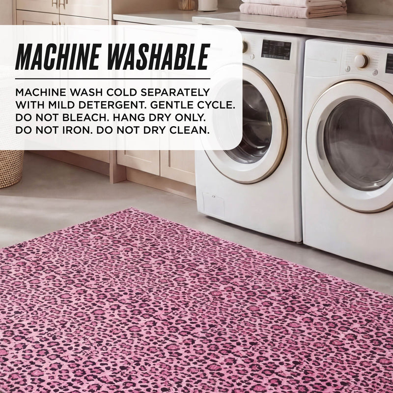 A laundry room features two front-loading washers, light cabinets, and a pink leopard print Finely Washable Rug (7'10" x 10') with non-skid backing. Text overlay provides machine washing instructions for the rug.