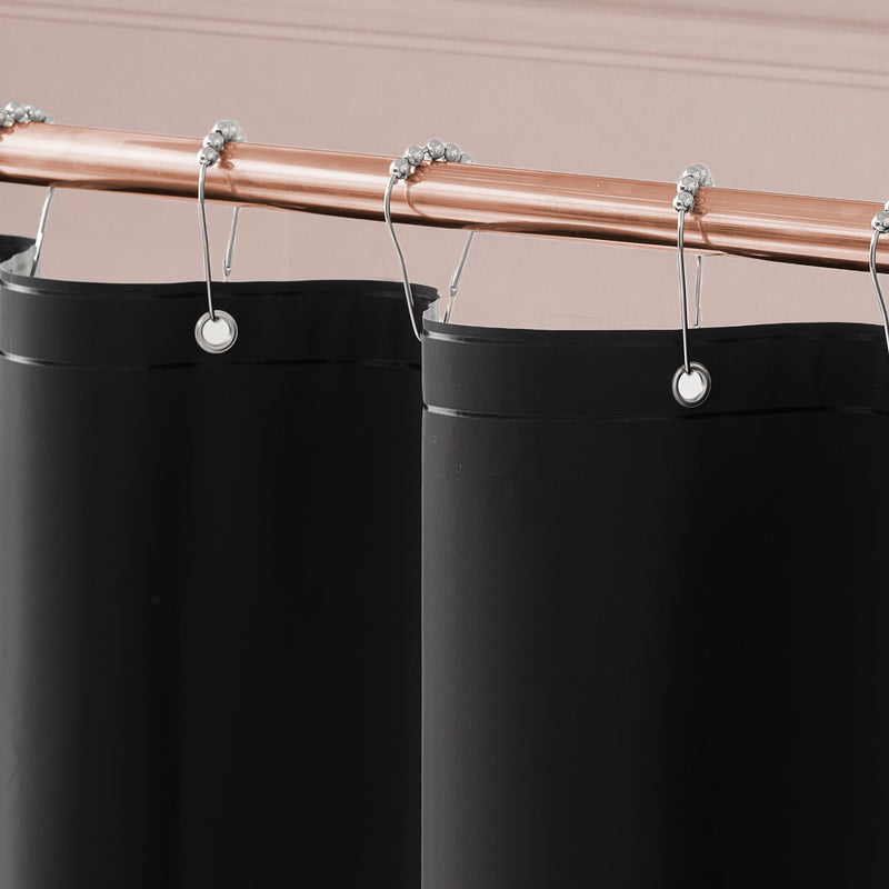 The Bow Leopard Shower Curtain with PEVA Liner and Hooks 14-Piece Set hanging from a copper-colored rod with silver curtain rings makes a bold statement in your bathroom decor, beautifully contrasting against the light pink wall.