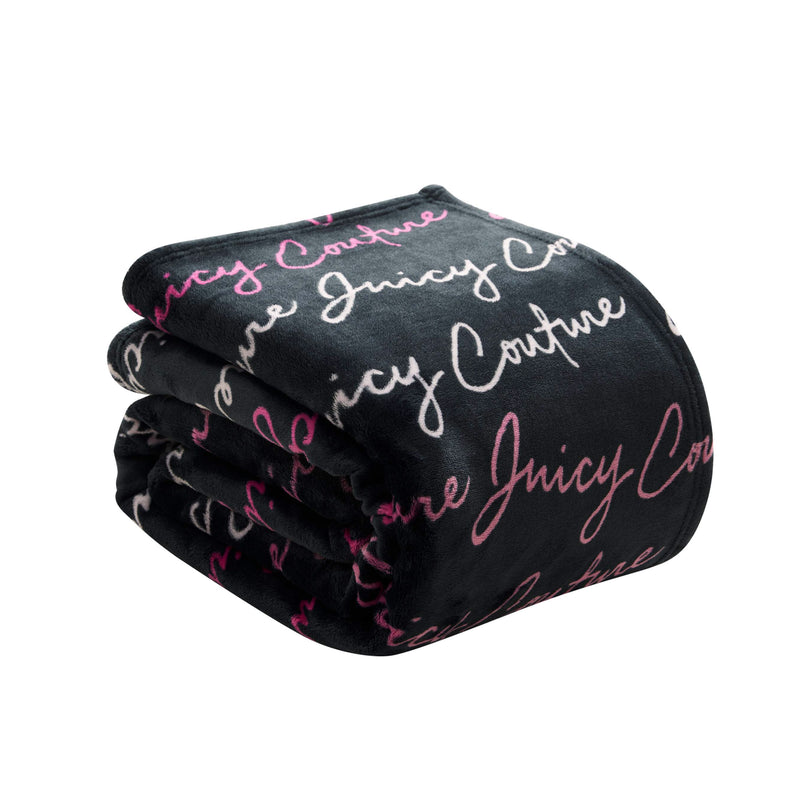 A folded black Plush Oversized Throw Blanket, ultra-soft and plush, featuring "Juicy Couture" repeatedly in white and pink cursive lettering.