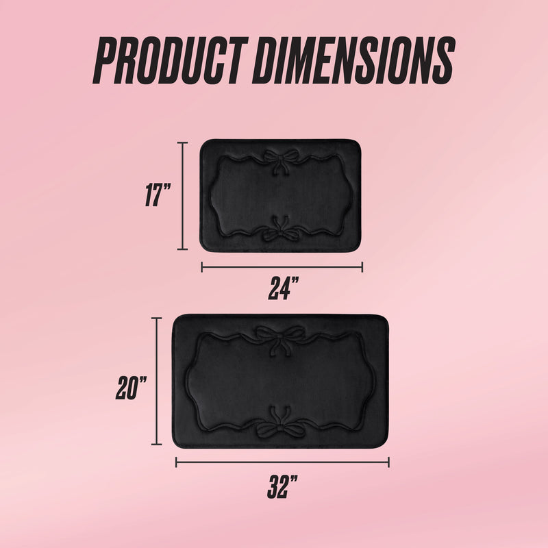 Two black rectangular Quilted Memory Foam Bath Mats with decorative edges are shown on a pink background, measuring 17 x 24 and 20 x 32. The text "PRODUCT DIMENSIONS" appears at the top.