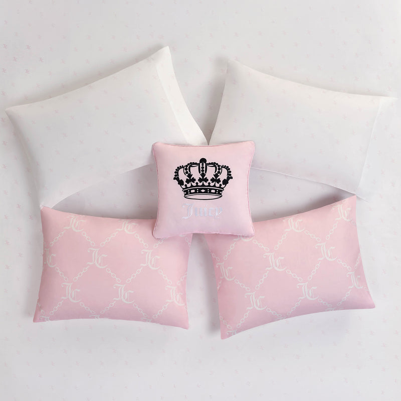 The Link Printed Bed in a Bag Bedding Set features five star-arranged pillows: three white, two patterned light pink, and a smaller pink center pillow with a black crown and "JUICY"—ideal for glam bedding.