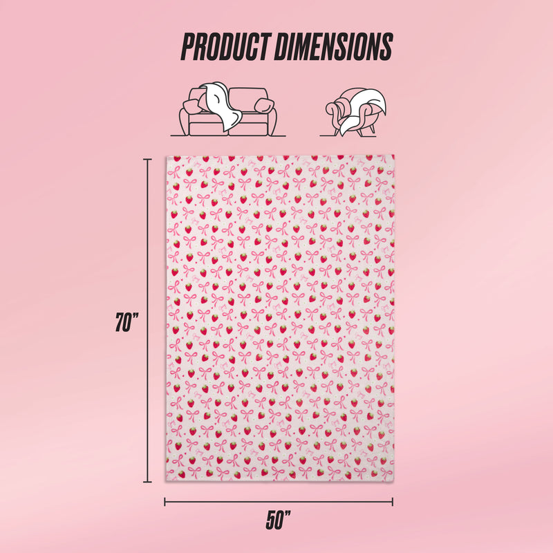 A Kids Plush Throw Blanket by Juicy Couture features a pink cherry pattern and measures 70x50 inches. Icons indicate sofa and wearable uses, while a soft pink gradient background highlights the ultra-soft plush texture. Text: Product Dimensions.