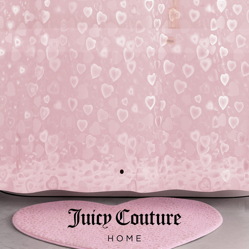 A pink PEVA Shower Curtain Liner with translucent heart patterns and "Juicy Couture Home" printed in black at the bottom, paired with a matching pink heart-shaped bath rug.